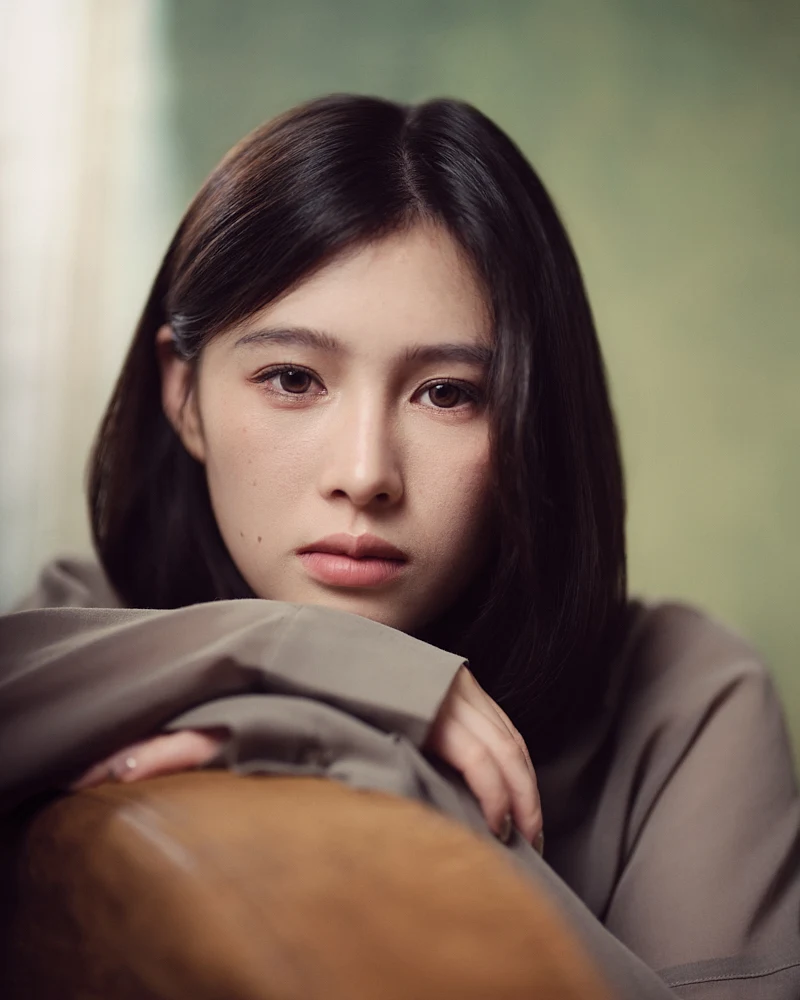 Cinematic, intimate close-up portrait of a woman with soft lighting highlighting her eyes and a gentle expression, with a shallow depth of field.